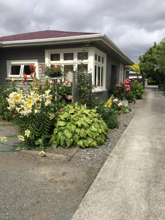 a house with a bunch of flowers in front of it at Stay@10 in Blenheim