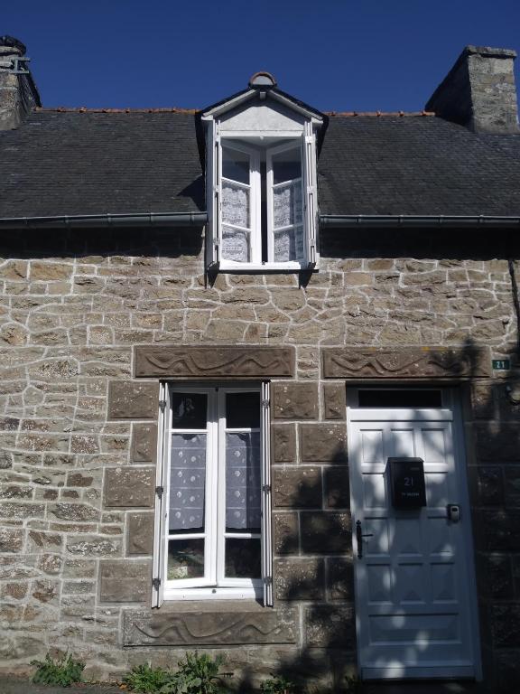 a stone building with two windows and a door at Ty Gwenn la veritable Bretagne in Plésidy