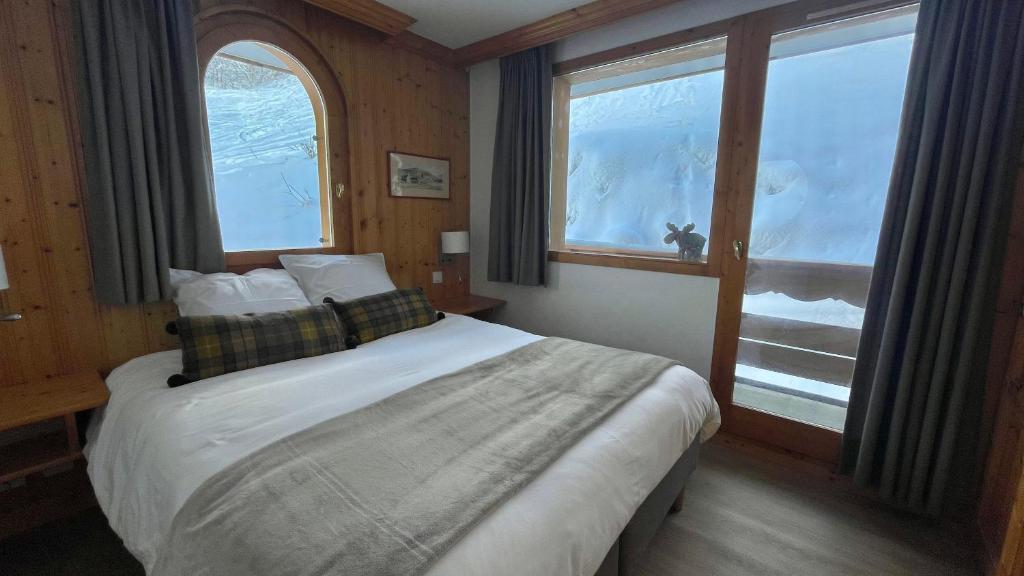 Meribel Centre La Chaudanne - ski in and out apartment - 3 bedrooms - 1 min to main ski lifts and 5 min to center of Meribel - newly renovated in Oct 2023 - Chalet l'Épervière في ميريبيل: غرفة نوم بسرير ونافذة كبيرة