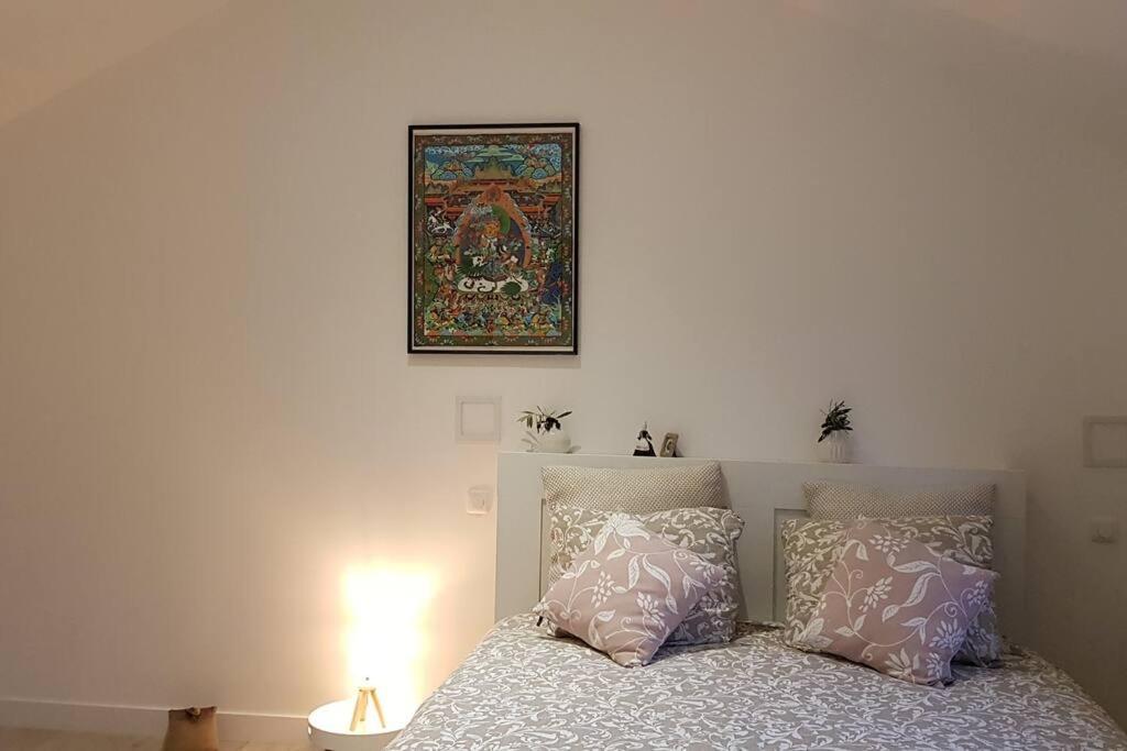 a bedroom with a bed with a picture on the wall at ty-yan in Tours