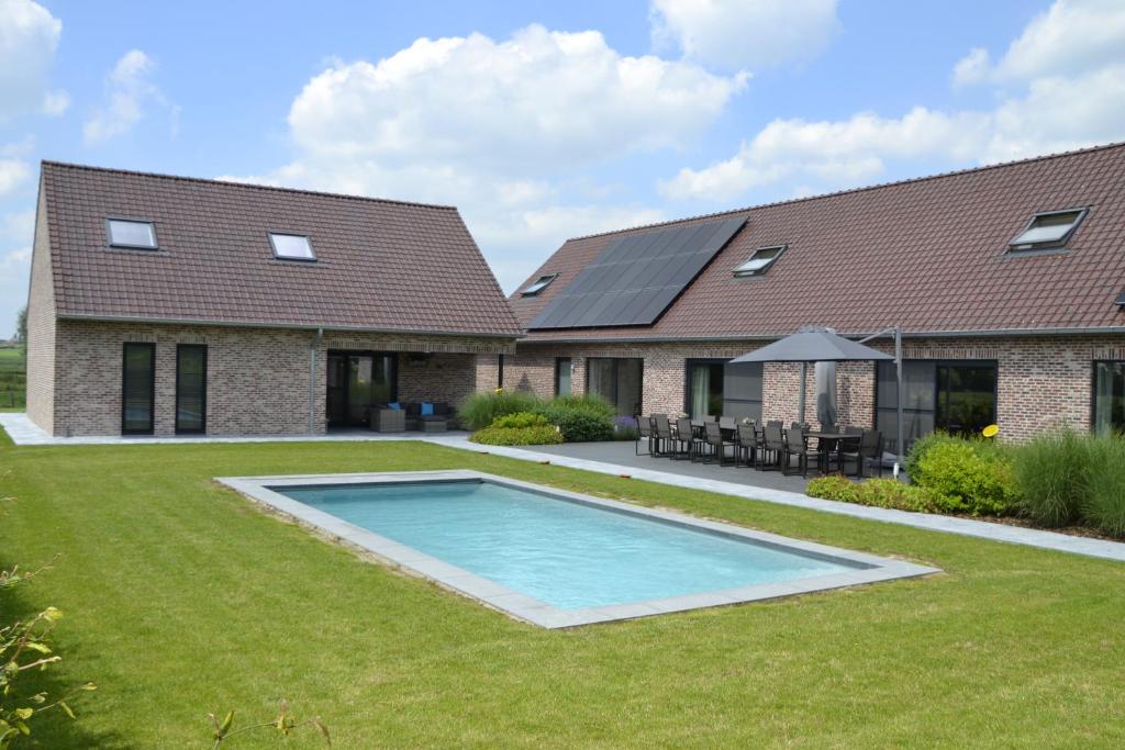 a house with a swimming pool in the yard at Landhuis Soetendaele in Wervik