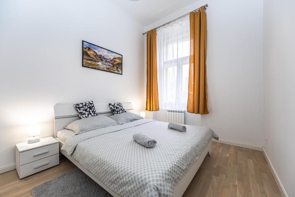 a white bedroom with a bed and a window at Stylish Apartment at Wenceslas Square in Prague