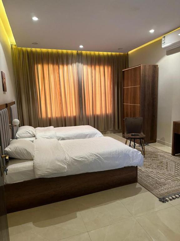 a bedroom with a large bed and a window at أجنحة رونق العلا 2 in AlUla