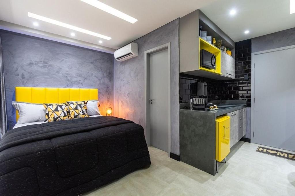 a bedroom with a large bed and a kitchen at MY512 - Bela Vista - Studio Moderno "Próx. a Paulista" in Sao Paulo