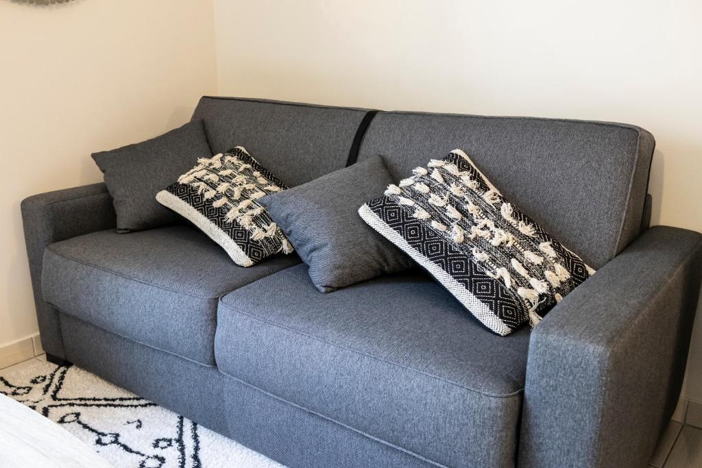 a blue couch with two pillows on it at Charmant studio en résidence avec parking in Bussy-Saint-Georges