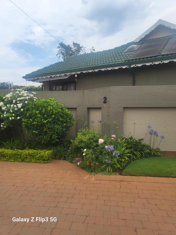 a house with a garage and flowers in front of it at Lotus 5a in Brakpan