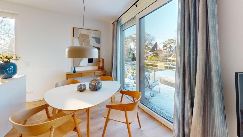 a dining room with a table and chairs and a large window at Strandglück in Timmendorfer Strand