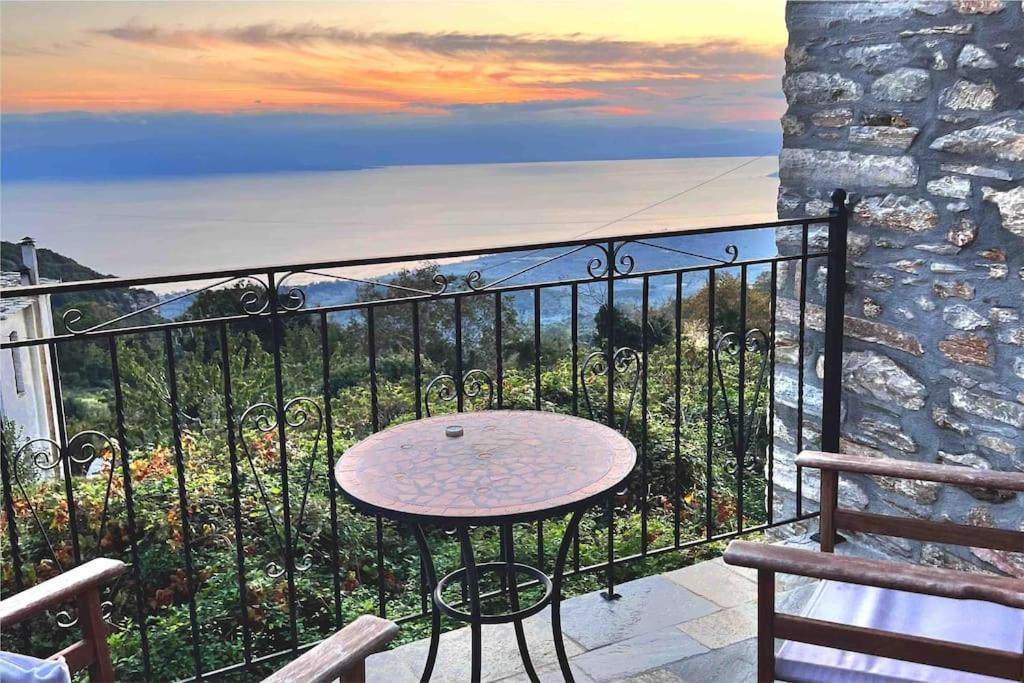 a table on a balcony with a view of the ocean at Magical cottage! in Agios Georgios Nilias