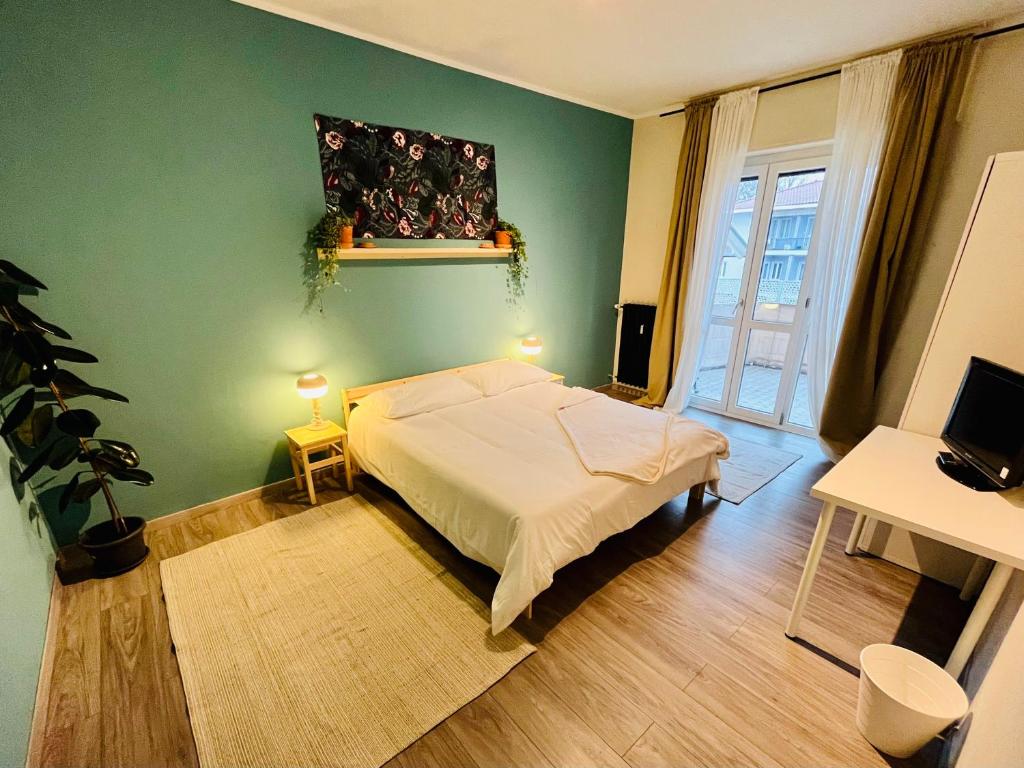1 dormitorio con cama y pared verde en Salvandola, en Ivrea