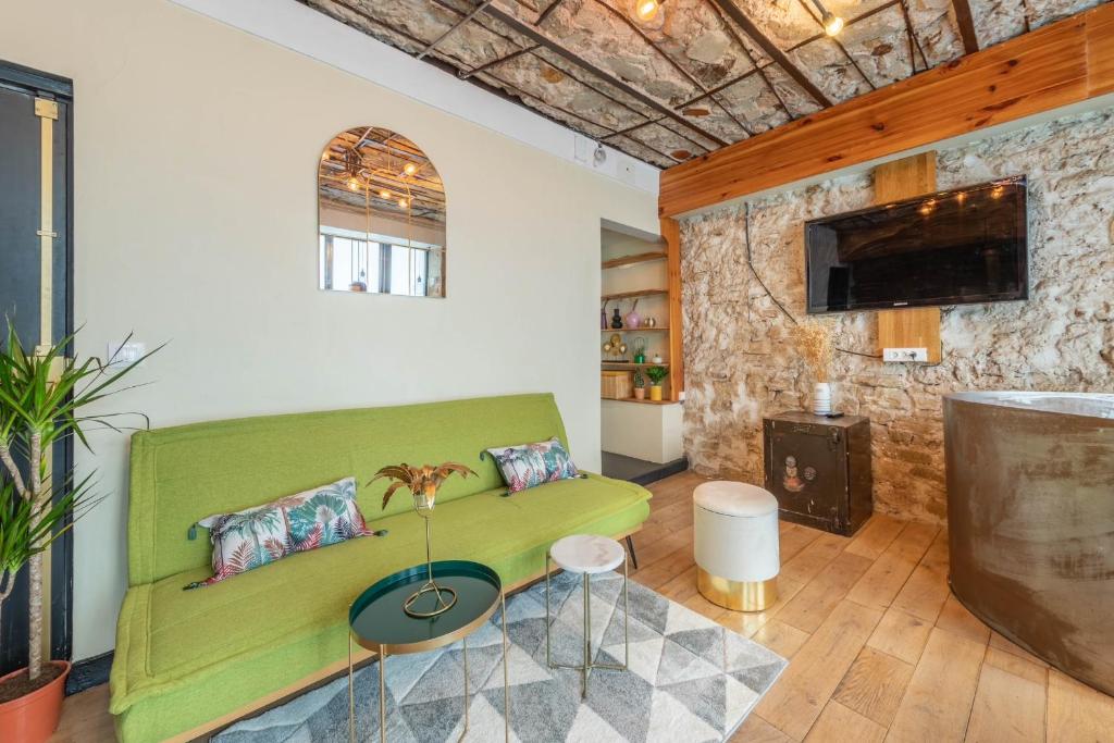 een woonkamer met een groene bank en een open haard bij Incroyable appartement Parisien in Parijs