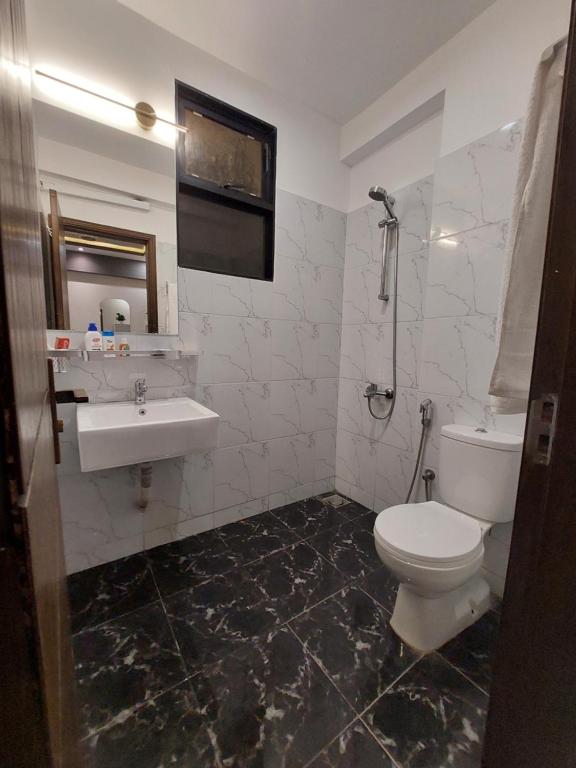 a bathroom with a toilet and a sink at Travellers Heaven 3BR APT DHA PHASE VI in Karachi
