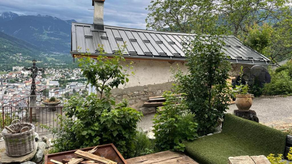 een tuin met planten en een gebouw met uitzicht bij Rustic fireplace hotel comfort Jaccuzi dog friend in Bourg-Saint-Maurice