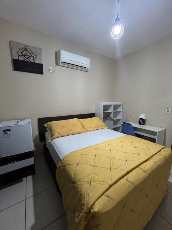 1 dormitorio con 1 cama con edredón amarillo en Pousada Riosmar, en Balneário Camboriú