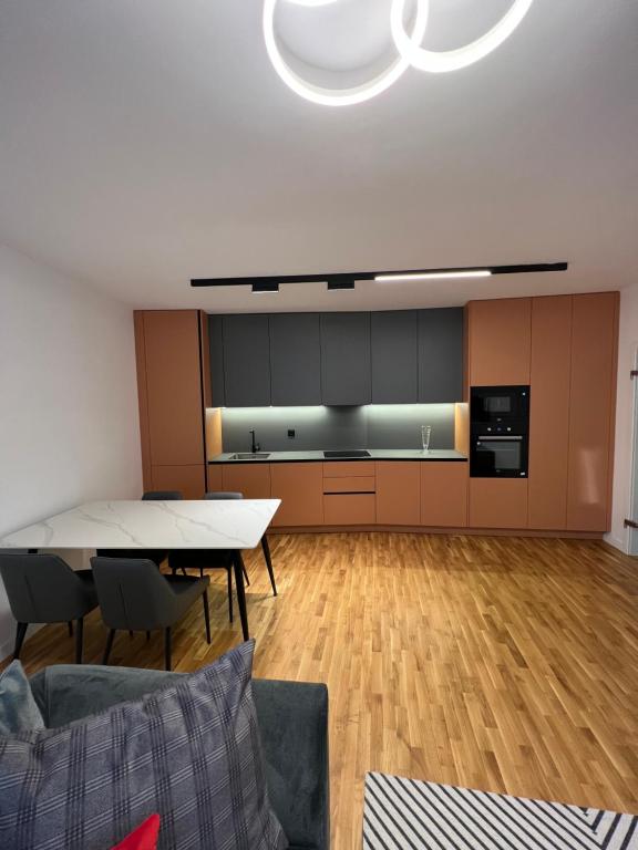a living room with a table and a kitchen at Four Seasons Apartment in Pristina