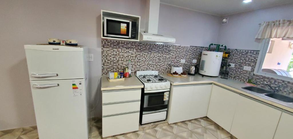 a kitchen with a white refrigerator and a stove at La Bicicleta in Aldea Camarero