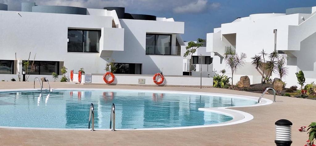 a building with a swimming pool in front of a building at Casilla de Costa Luz Home con Terrazza Fronte Piscina in La Oliva