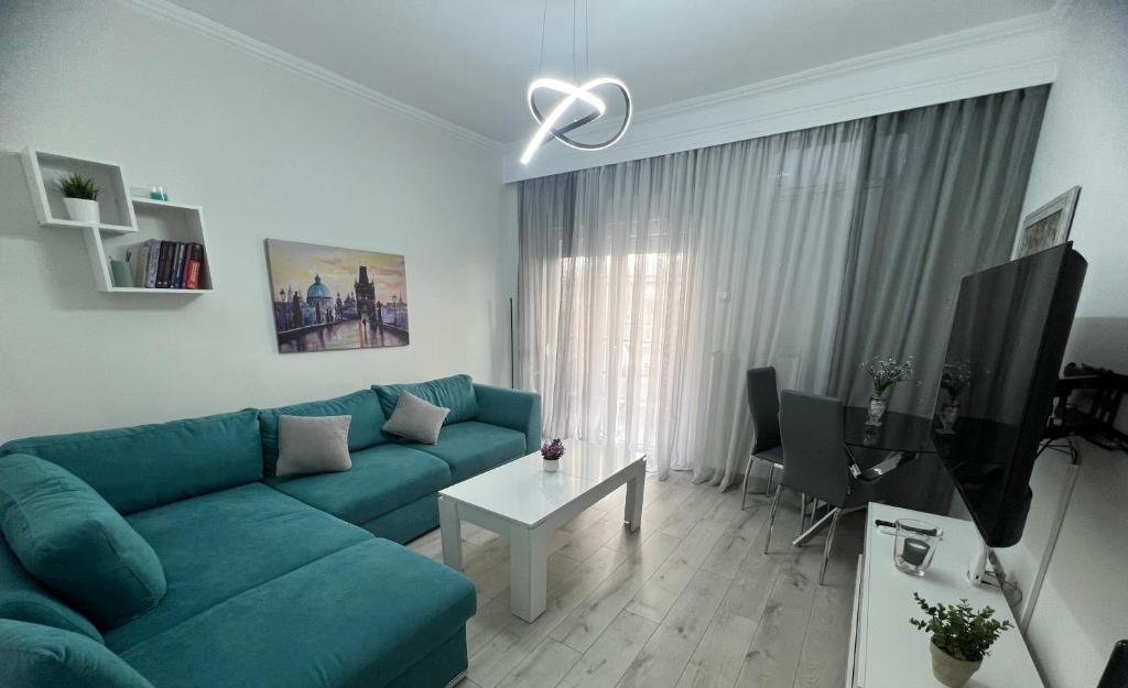 un soggiorno con divano blu e tavolo di Serres city center modern apartment (Monika) a Serres