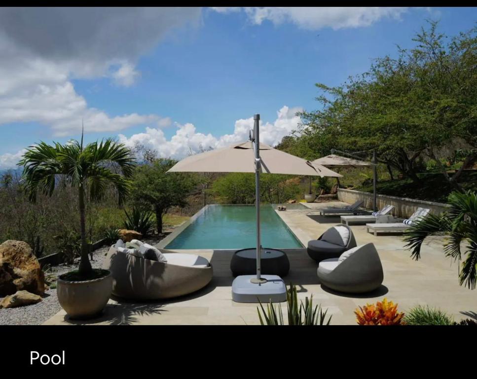 een zwembad met ligstoelen en een parasol bij Casa Vero in Villanueva