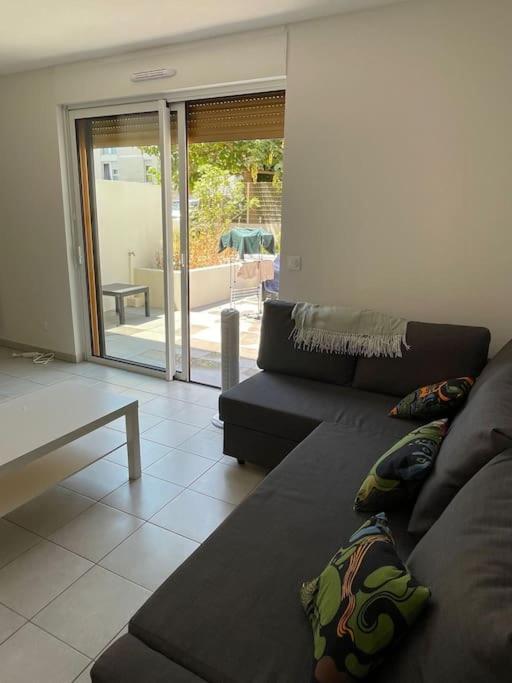 un salon avec un canapé et une table dans l'établissement Charmant duplex à Montpellier pour 4 personnes, wifi, parking et tramway, à Montpellier