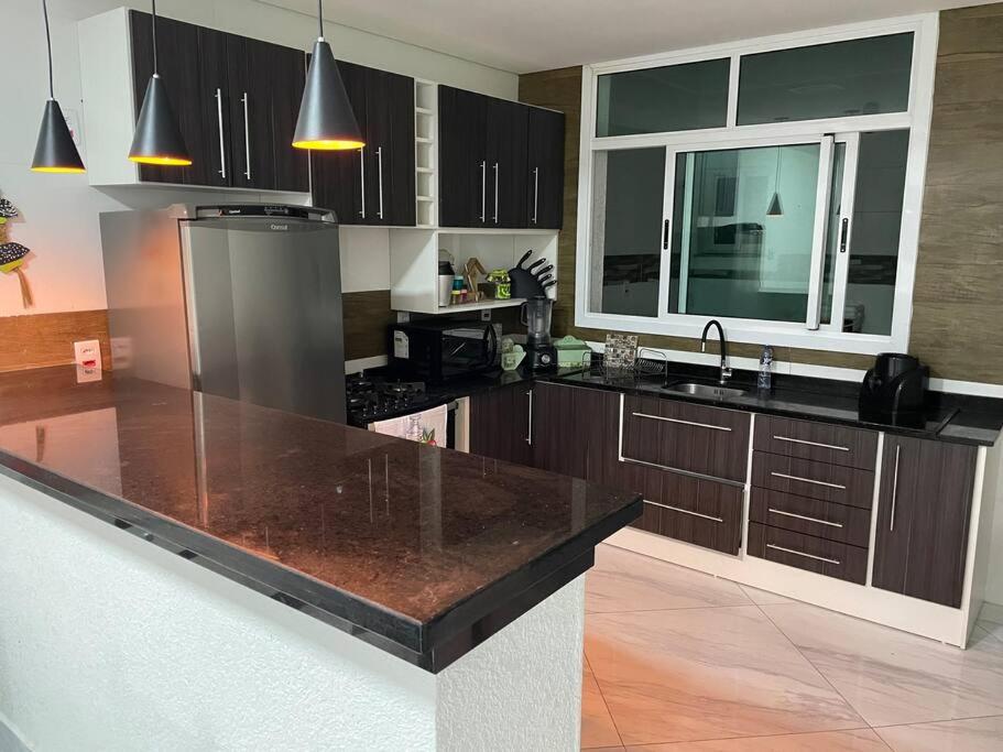 a kitchen with a large island in the middle at The Brown beach House in Rio Grande