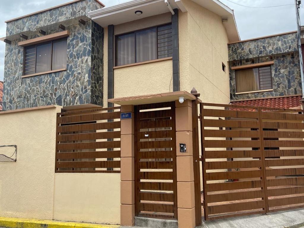 a house with a wooden fence in front of it at CASA NUEVA, CON DECORACIONES Y ACABADOS NUEVOS SOLO PARA FAMILIAS. in Cuenca