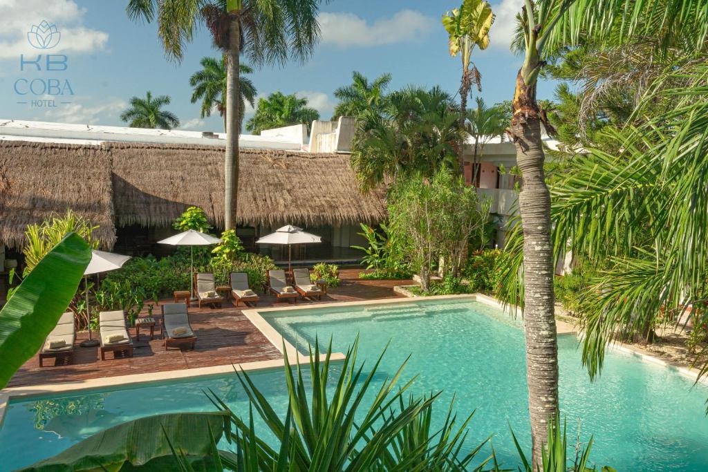 una piscina en un complejo con palmeras en Kaab Coba en Cobá