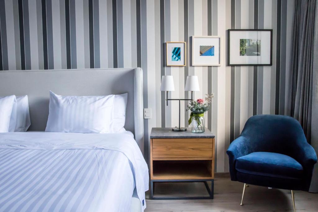 1 dormitorio con 1 cama y 1 silla azul en Zamora Exclusive By Mr W, en Ciudad de México