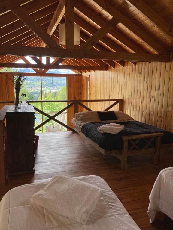 1 dormitorio con 2 camas en un edificio de madera en Horizonte Chapelco en San Martín de los Andes