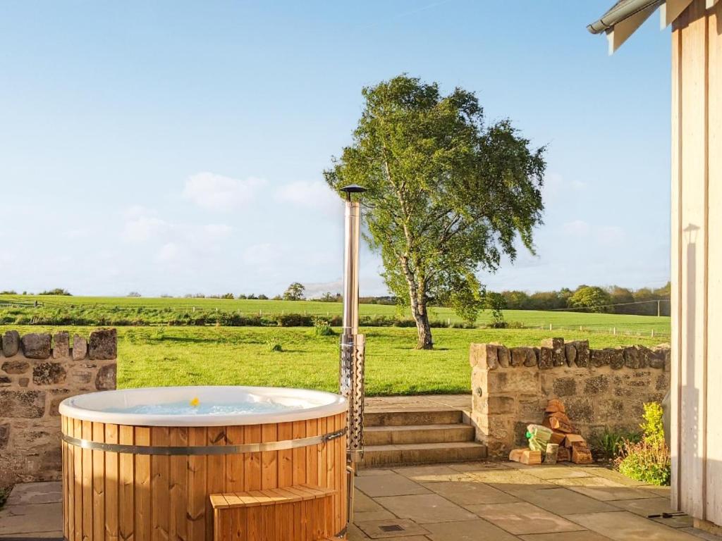 a jacuzzi tub in the yard of a house at Broomrigg Farmhouse in Pencaitland