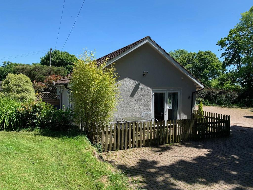 a small house with a fence in front of it at Rosemary Cottage-uk42032 in Highampton