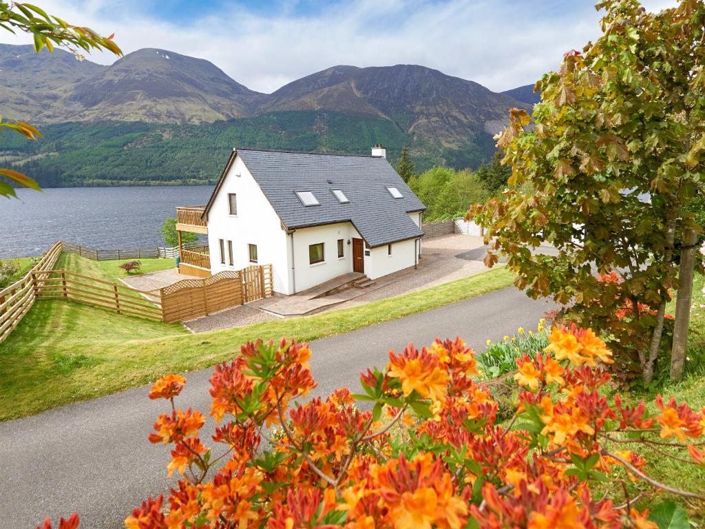 una casa al lado de un lago con montañas en Skye Fall, en Letterfinlay