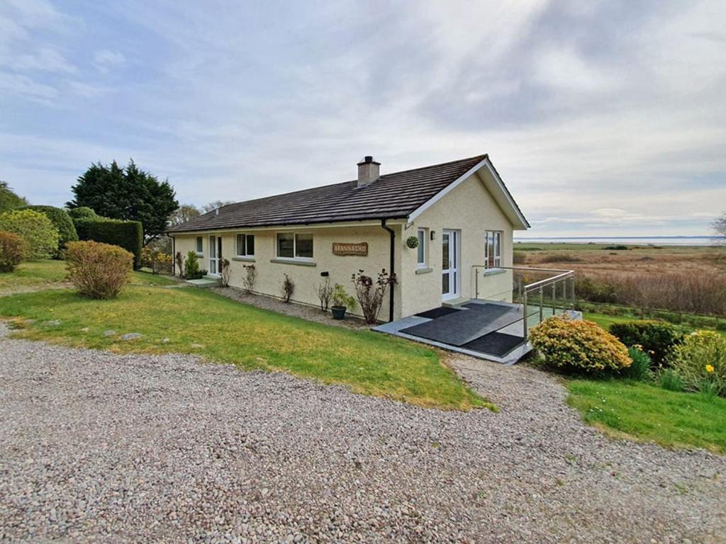 a small white house with a gravel driveway at Beannachd in Evelix