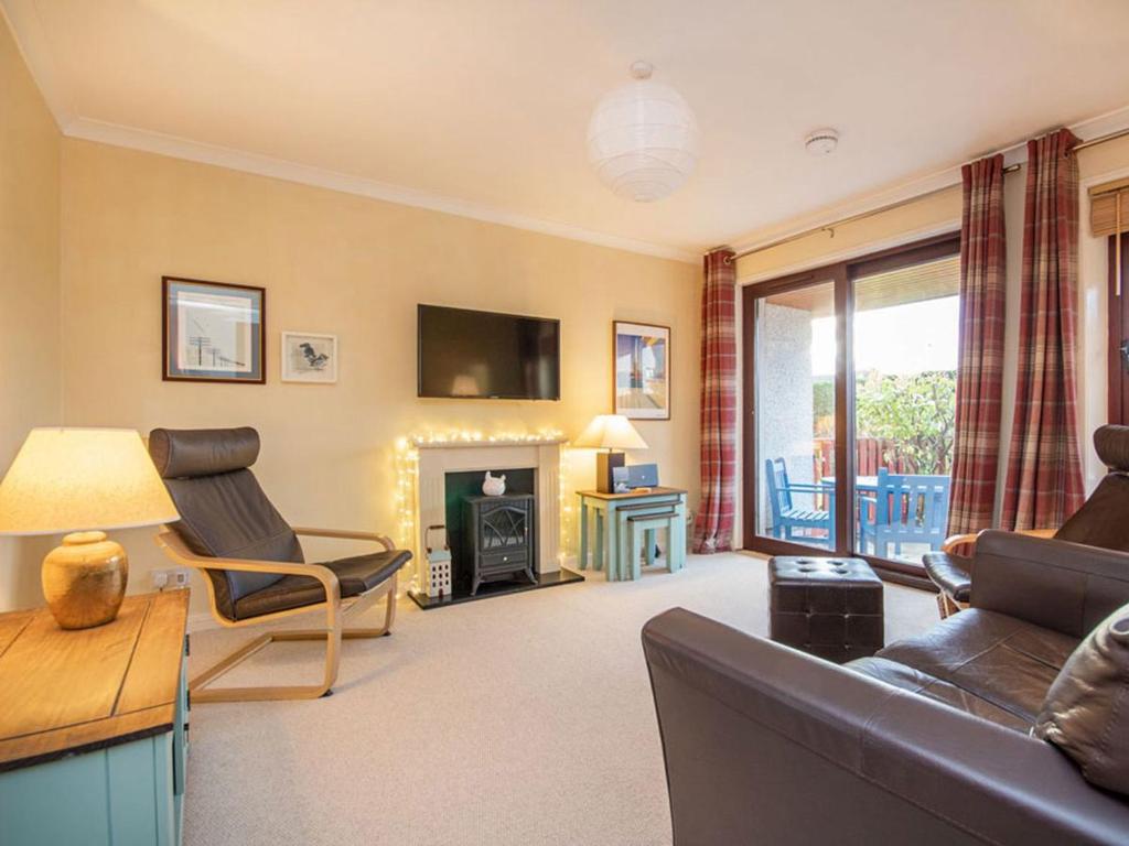 a living room with a couch and a fireplace at Strathy in Dornoch