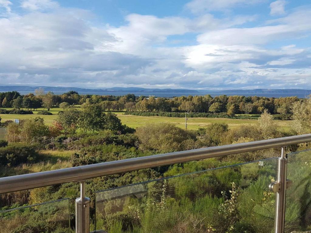 a view of a field from a balcony at Fairway Apartment in Nairn