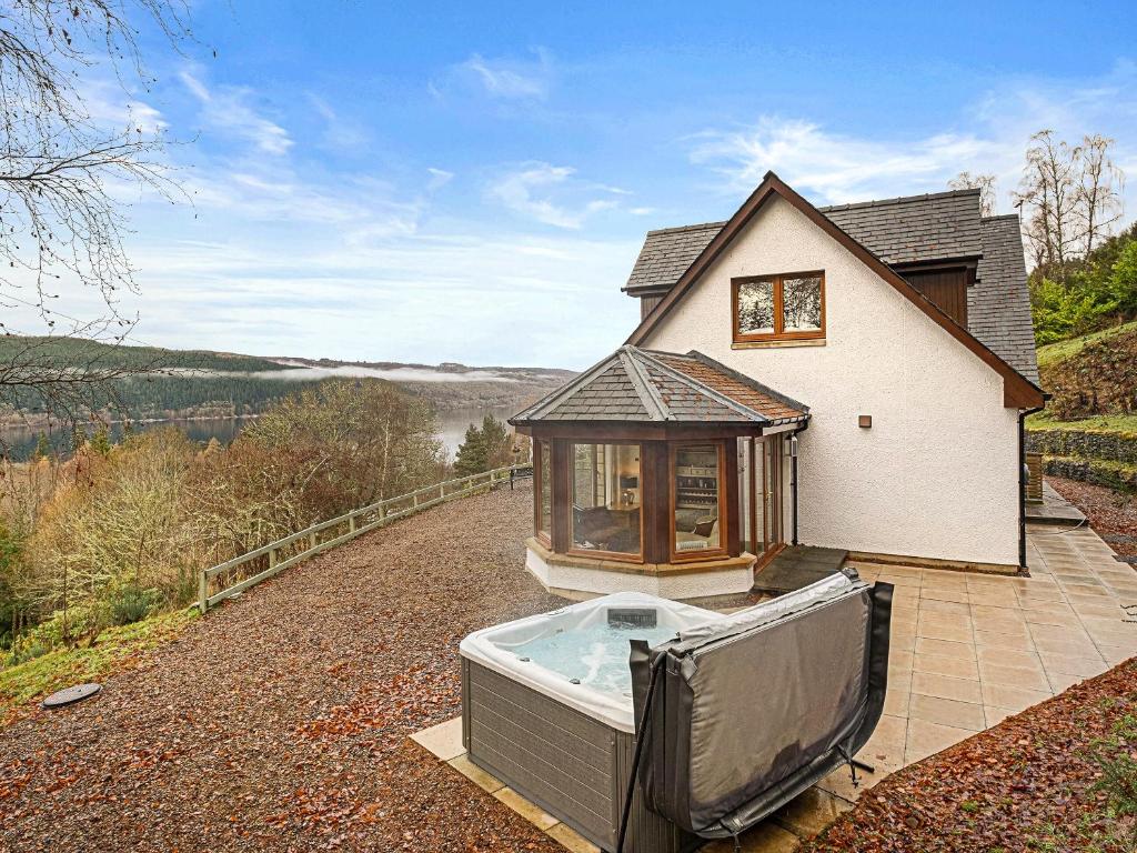 a house with a hot tub in front of it at Taigh Geal in Foyers