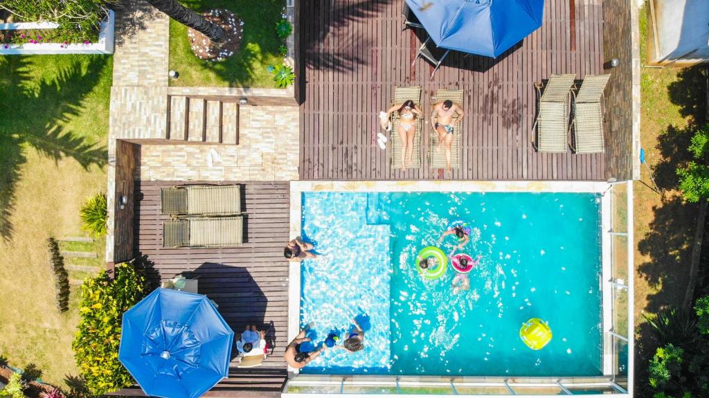 uma vista superior de uma piscina com pessoas em fatos de banho e guarda-sóis em Pousada Villa Casablanca em Búzios