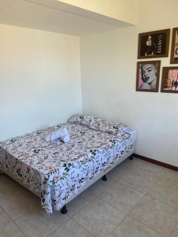 a bedroom with a bed with a flowered blanket at O Paraíso é aqui: Pé na Areia em Arembepe in Camaçari