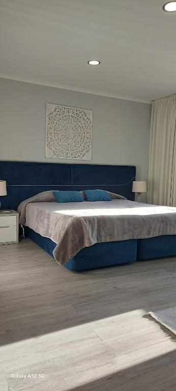 a bedroom with a large bed with blue pillows at Pinneapple Studio in Ponta Delgada