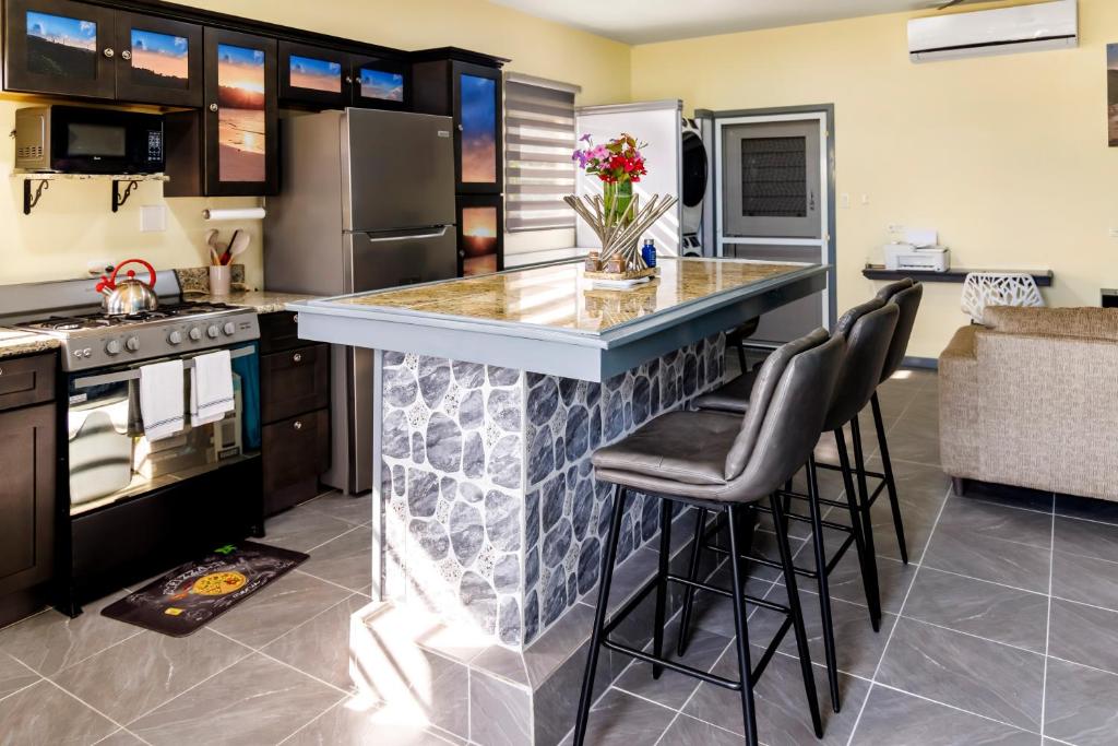 a kitchen with a counter and stools in a kitchen at Elleamau in Island Harbour