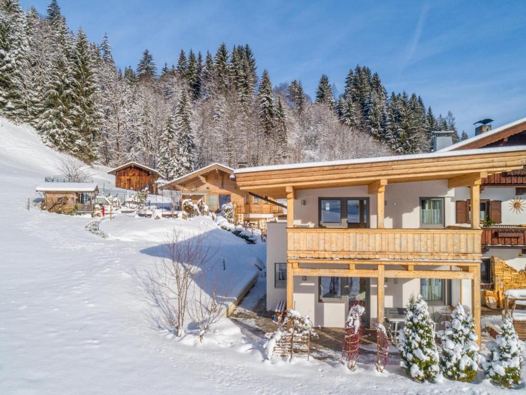 una casa de madera en la nieve con árboles en Blick auf den Rettenstein Top 2, en Kirchberg in Tirol