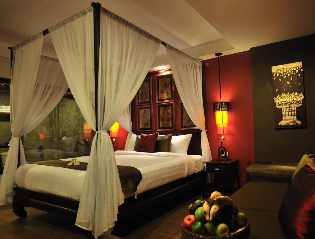 a bedroom with a bed and a bowl of fruit at Siralanna Hotel in Patong Beach