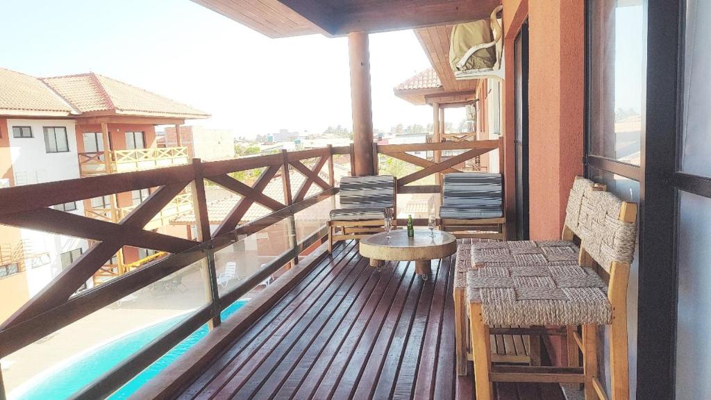 een balkon met een tafel en stoelen en een zwembad bij Vila Atlântida- Atalaiaape307-B in Luis Correia