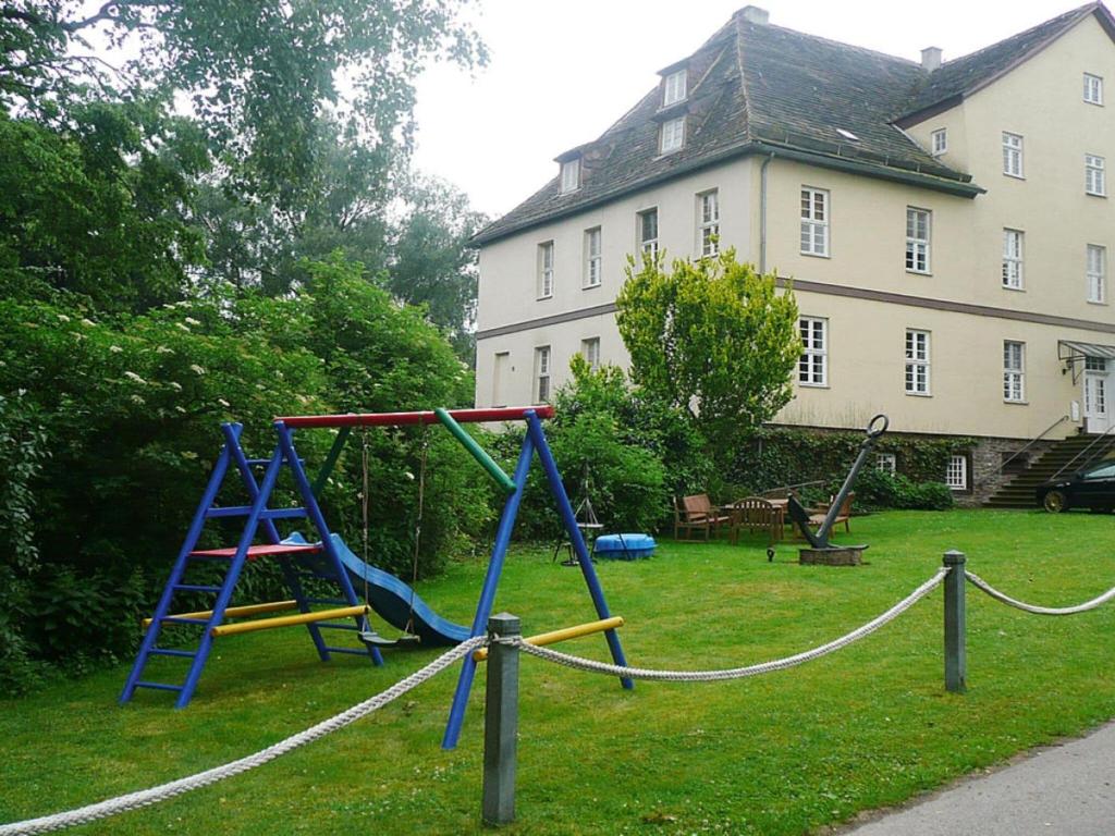 un parque infantil frente a un edificio con una casa en Holiday Apartment Kemenate, 