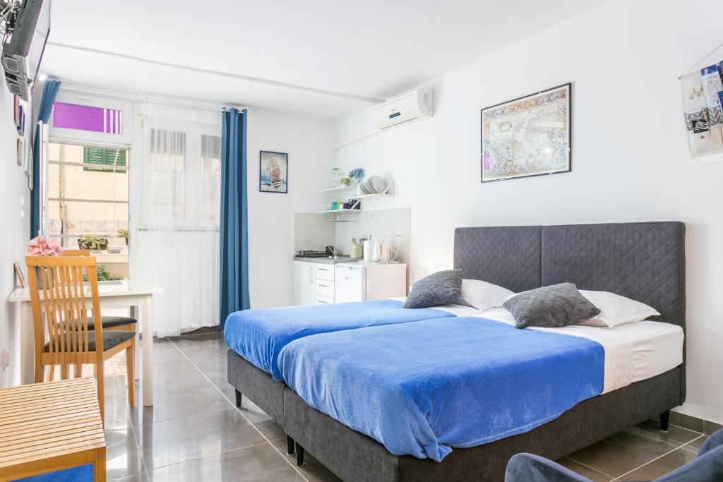 a bedroom with a blue bed and a kitchen at Apartments with a parking space Split - 14051 in Split