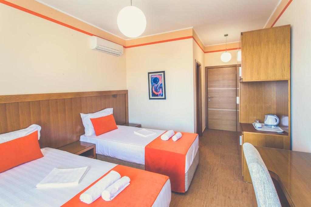 a hotel room with two beds and a table at Apartments Deus in Dobra Voda