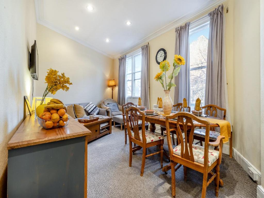 een keuken en een woonkamer met een tafel en stoelen bij The Flat in Whitchurch