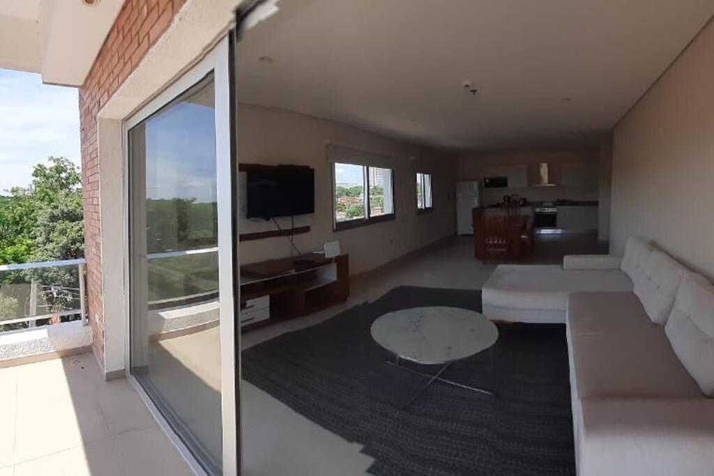 uma sala de estar com um sofá e uma mesa em Edificio Carmelitas insuperable una habitación em Assunção