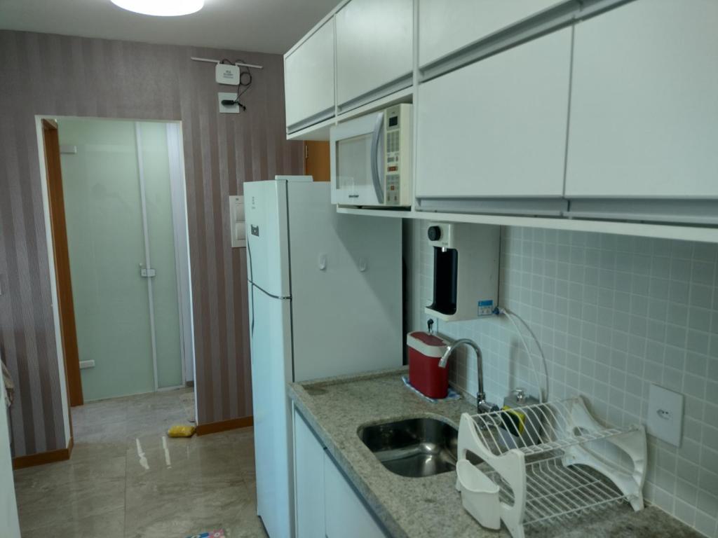uma cozinha com um lavatório e um frigorífico branco em Excelente apartamento 02 quartos frente ao mar em Salvador