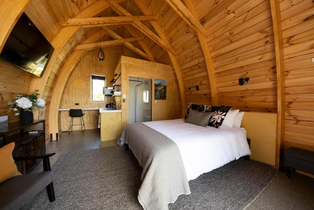 a bedroom with a bed in a wooden cabin at Benger Garden Chalets in Millers Flat