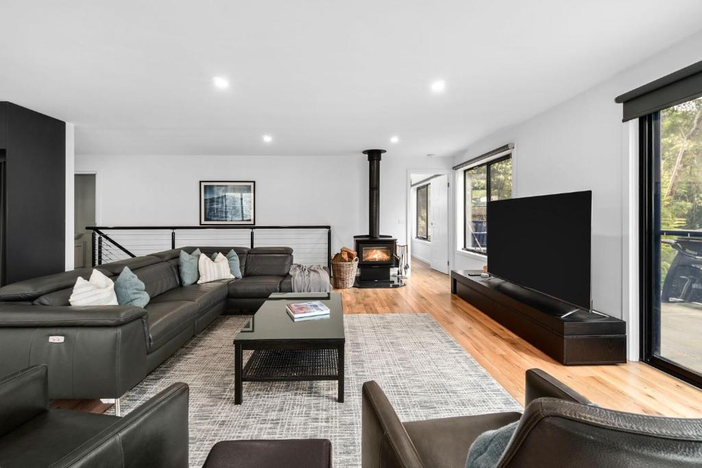 a living room with a couch and a flat screen tv at The Wave House in Wye River
